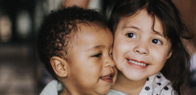 Two young children embracing closely.